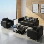 5-seater office sofa set in smooth black faux leather, featuring a three-seater couch and two matching single-seater armchair sofas, all styled with distinctive square grid tufting across the backrests and seats, straight block armrests, and sleek silver metal corner feet.