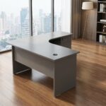 1.2M curved office desk in a sleek charcoal gray matte finish, featuring a smooth L-shaped corner tabletop with an integrated cable grommet, a matching privacy modesty panel, and an attached three-drawer under-desk storage pedestal with lockable top drawer and curved handles.