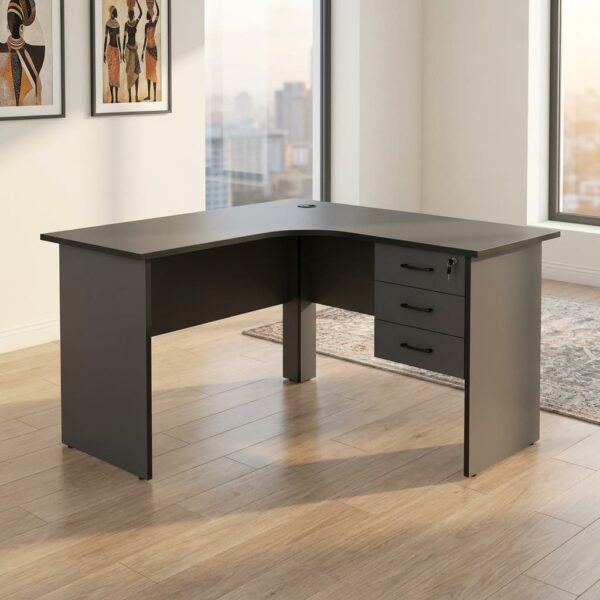 1.2M curved office desk in a sleek charcoal gray matte finish, featuring a smooth L-shaped corner tabletop with an integrated cable grommet, a matching privacy modesty panel, and an attached three-drawer under-desk storage pedestal with lockable top drawer and curved handles.