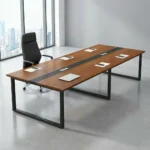 12-seater boardroom table featuring a long rectangular tabletop finished in a warm teak wood grain veneer, styled with a contrasting black running center stripe that houses two silver flip-top cable management grommets, all supported by a heavy-duty industrial matte black metal sled base.