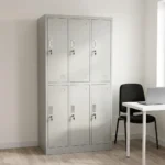 Light grey 6-door steel locker cabinet with recessed handles, individual key locks, and ventilation louvers next to an office desk.