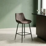 Dark gray faux leather barstool with a ribbed vertical-tufted backrest and tapered black metal legs with a built-in footrest.