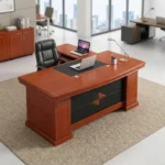 1.6m executive office desk in a rich reddish-brown cherry wood veneer finish, featuring a traditional rectangular tabletop with an integrated black leather desk blotter inlay, an attached side return credenza, and a black front modesty panel detailed with a central diamond-shaped wood accent.