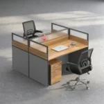 2 way office workstation arranged in a face-to-face configuration, featuring natural wood grain tabletops enclosed by charcoal gray privacy partition panels topped with frosted glass dividers, paired with a matching under-desk three-drawer mobile filing cabinet with lock.