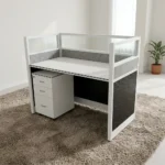 1-Way Office Workstation featuring a solid white desktop paired with a matching white under-desk three-drawer mobile filing cabinet with a key lock, enclosed by modern charcoal gray framed privacy partition panels decorated with a textured geometric pattern and topped with clear glass dividers.