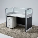 1-Way Office Workstation featuring a solid white desktop paired with a matching white under-desk three-drawer mobile filing cabinet with a key lock, enclosed by modern charcoal gray framed privacy partition panels decorated with a textured geometric pattern and topped with clear glass dividers.