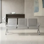 3 seater heavy duty waiting bench constructed from durable silver powder-coated steel, featuring three interconnected seats with perforated mesh backrests and contoured seating surfaces, bordered by polished chrome loop armrests on each end, and supported by heavy-duty arched metal legs with adjustable leveling glides.