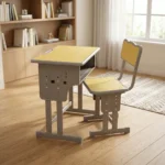 Kids study desk and chair set featuring a height-adjustable design, with both pieces supported by a durable matte gray steel frame. The desk is constructed with a rectangular light yellow top with a light blue safety border, an integrated open-front book storage shelf underneath, and T-leg bases, paired with a matching ergonomic chair featuring a yellow seat and backrest trimmed in light blue.