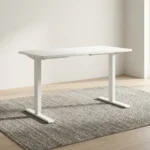 1.2m white electric desk featuring a clean rectangular desktop with rounded corners, dual circular white cable grommets, a black under-desk digital control keypad, and a height-adjustable white telescoping T-leg base.