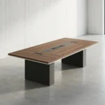 2.4m conference meeting table featuring a natural wood-grain tabletop with white edge trim, a central black media connectivity panel, and dual charcoal gray block pedestal legs.