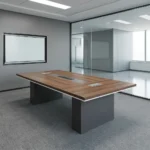 2.4m conference meeting table featuring a natural wood-grain tabletop with white edge trim, a central black media connectivity panel, and dual charcoal gray block pedestal legs.
