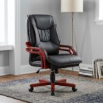 Directors executive office chair featuring a high-back black leather design with plush contoured cushioning and contrast stitching, curved reddish-brown wooden armrests, and a matching wooden five-star swivel base.