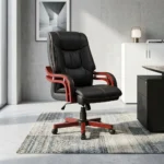 Directors executive office chair featuring a high-back black leather design with plush contoured cushioning and contrast stitching, curved reddish-brown wooden armrests, and a matching wooden five-star swivel base.
