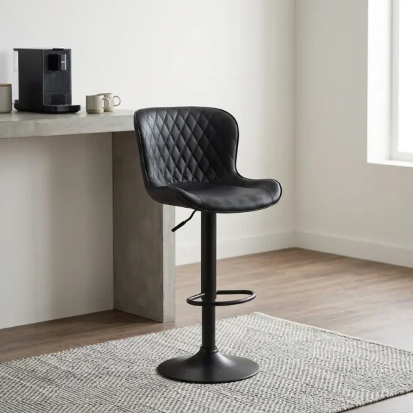 Black leather adjustable barstool featuring a curved bucket-style seat with diamond-quilted black leather upholstery, a matte black height-adjustable pedestal stand with a built-in oval footrest, and a matching circular trumpet base.
