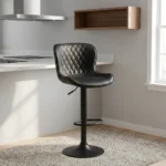 Black leather adjustable barstool featuring a curved bucket-style seat with diamond-quilted black leather upholstery, a matte black height-adjustable pedestal stand with a built-in oval footrest, and a matching circular trumpet base.