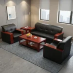 5-seater executive office sofa set featuring premium black leather upholstery with block-tufted backrests and padded headrests, accented by polished reddish-brown wooden panels capping the armrests, including a three-seater sofa and two matching single-seater armchairs.