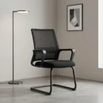 Premium office visitor chair featuring a mid-back black mesh backrest with an integrated horizontal lumbar support pad, curved black loop armrests, a contoured padded black seat, and a durable matte black cantilever sled base.