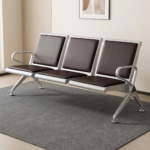Heavy duty reception waiting bench featuring a robust three-seater silver metallic frame, padded black leather seat and backrest cushions for each section, integrated curved silver armrests at both ends, and angled support legs with adjustable leveling feet.