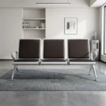 3-link black waiting bench featuring a robust three-seater silver metallic frame, padded black leather seat and backrest cushions for each section, integrated curved silver armrests at both ends, and angled support legs with adjustable leveling feet.