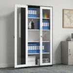 Full-glass steel office cabinet featuring a modern two-tone design with a black outer frame and white-trimmed double doors, large clear glass panels showcasing multi-tier internal shelving, a sleek integrated vertical handle, and a central key-lock mechanism.