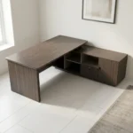 1.8m L-shaped office table featuring a premium dark wood-grain finish, an L-shaped configuration with an attached side return credenza, a thick floating-style tabletop, a front modesty panel accented by a thin gold horizontal line, and a unique gray side pedestal cabinet decorated with an "X" stitch pattern and a central gold accent tab.