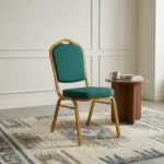 Stackable green banquet chair featuring a crown-top backrest and a thick square seat cushion, both upholstered in dark green fabric with a subtle gold fleck or dot pattern, supported by a sturdy gold-finished metallic frame with integrated stacking bumpers.