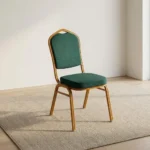 Stackable green banquet chair featuring a crown-top backrest and a thick square seat cushion, both upholstered in dark green fabric with a subtle gold fleck or dot pattern, supported by a sturdy gold-finished metallic frame with integrated stacking bumpers.