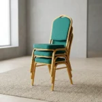 Green stackable banquet chair featuring a crown-top backrest with a cut-out handle and a thick square seat cushion, both upholstered in dark green fabric with a subtle gold dot or diamond pattern, shown in a vertical stack of three supported by a sturdy gold-finished metallic frame with white stacking bumpers.