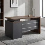 140cm executive office desk featuring a modern two-tone design with a warm wood-grain tabletop, a blocky charcoal-gray side pedestal cabinet on the left supporting a floating-style top, a matching wood-grain right leg panel, and a front modesty panel in charcoal-gray accented by two horizontal silver stripes.