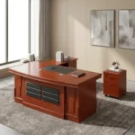 2.0m executive office desk featuring a rich reddish-brown wood-grain finish, an L-shaped layout with an attached side return credenza, an embedded black leather desktop writing pad, a front modesty panel decorated with two columns of segmented black textured panels, and a matching independent three-drawer mobile filing pedestal.