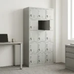 15-locker steel filing cabinet featuring a durable light-gray metal frame organized in a 3-column by 5-row grid of individual compartments, each equipped with an integrated vertical handle, label holder slot, individual key lock, and lower ventilation louvers