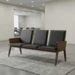 Heavy duty reception bench featuring a 3-seat design upholstered in sleek black leather with padded backrests and seat cushions, supported by a robust dark walnut-finish wood frame with angled legs and wood-paneled side armrests.