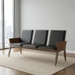 Heavy duty reception bench featuring a 3-seat design upholstered in sleek black leather with padded backrests and seat cushions, supported by a robust dark walnut-finish wood frame with angled legs and wood-paneled side armrests.