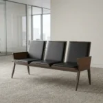 Heavy duty reception bench featuring a 3-seat design upholstered in sleek black leather with padded backrests and seat cushions, supported by a robust dark walnut-finish wood frame with angled legs and wood-paneled side armrests.