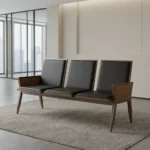 Heavy duty reception bench featuring a 3-seat design upholstered in sleek black leather with padded backrests and seat cushions, supported by a robust dark walnut-finish wood frame with angled legs and wood-paneled side armrests.
