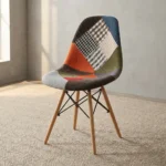 Modern patchwork Eames-style chair featuring a contoured shell seat upholstered in a multi-patterned fabric blend of houndstooth, plaid, and solid earthy tones, supported by natural wood dowel legs with black metal Eiffel-style wire bracing.