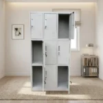 9-locker steel filing cabinet featuring a durable light-gray metal construction arranged in a 3-column by 3-row grid, with individual lockable compartments equipped with inset vertical handles, key-lock mechanisms, label holder slots, and lower ventilation louvers.