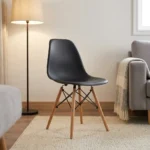 Black Eames-style dining chair featuring a molded matte black polypropylene shell seat, supported by natural wood dowel legs with black metal Eiffel-style wire bracing.
