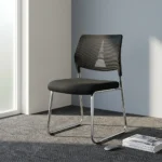 Stackable mesh visitor chair featuring a breathable black mesh backrest with a decorative geometric support accent, a armless design, a padded black fabric seat cushion, and a sleek chrome sled-base frame.