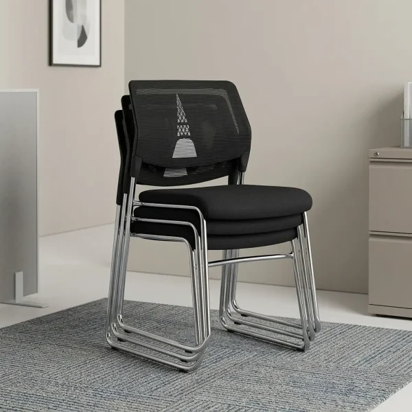 Mesh stackable waiting chair featuring a breathable black mesh backrest with a decorative geometric support accent, an armless space-saving design, a padded black fabric seat cushion, and a chrome-plated sled base shown in a stacked configuration.