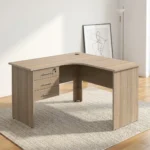 1.2m L-shaped office table featuring a light oak wood-grain laminate finish, a curved corner work surface, a built-in cable grommet, an integrated 3-drawer pedestal unit with lockable storage, sleek metal bar handles, and matching wooden panel legs.
