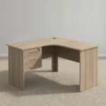 1.2m L-shaped office table featuring a light oak wood-grain laminate finish, a curved corner work surface, a built-in cable grommet, an integrated 3-drawer pedestal unit with lockable storage, sleek metal bar handles, and matching wooden panel legs.