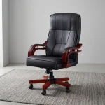 Bliss executive office seat featuring a high-back design upholstered in black leatherette with segmented ergonomic padding, mahogany-finish wooden armrests with chrome support accents, and a mahogany wooden-capped five-star swivel base with caster wheels.