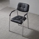 Stackable leather Catalina chair featuring grid-tufted black leatherette seat and backrest cushions, curved padded armrests, and a sleek chrome-plated tubular metal frame.