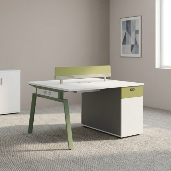 Two-way modular workstation featuring back-to-back white dual desk surfaces, a central olive green acoustic privacy divider screen, angled olive green steel A-frame legs, built-in cable management grommets, and an integrated side storage pedestal with a green top accent.