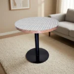 Round dining table featuring a white top with a subtle linear pattern and exposed layered plywood edge detail, supported by a central black metal pedestal pole and a sturdy flat circular base.