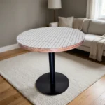 Round dining table featuring a white top with a subtle linear pattern and exposed layered plywood edge detail, supported by a central black metal pedestal pole and a sturdy flat circular base.