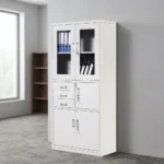Lockable office cabinet with safe featuring an all-white powder-coated steel construction, upper glass-panel double doors with internal shelving, a middle section with three stacked pull-out drawers alongside a lockable single-door safe compartment, and a lower set of lockable solid double doors.