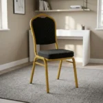 Stackable black banquet chair featuring black fabric upholstery patterned with gold polka dots, a padded crown-back backrest and seat, and a sturdy gold-finished metallic frame.