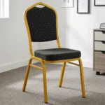 Stackable black banquet chair featuring black fabric upholstery patterned with gold polka dots, a padded crown-back backrest and seat, and a sturdy gold-finished metallic frame.